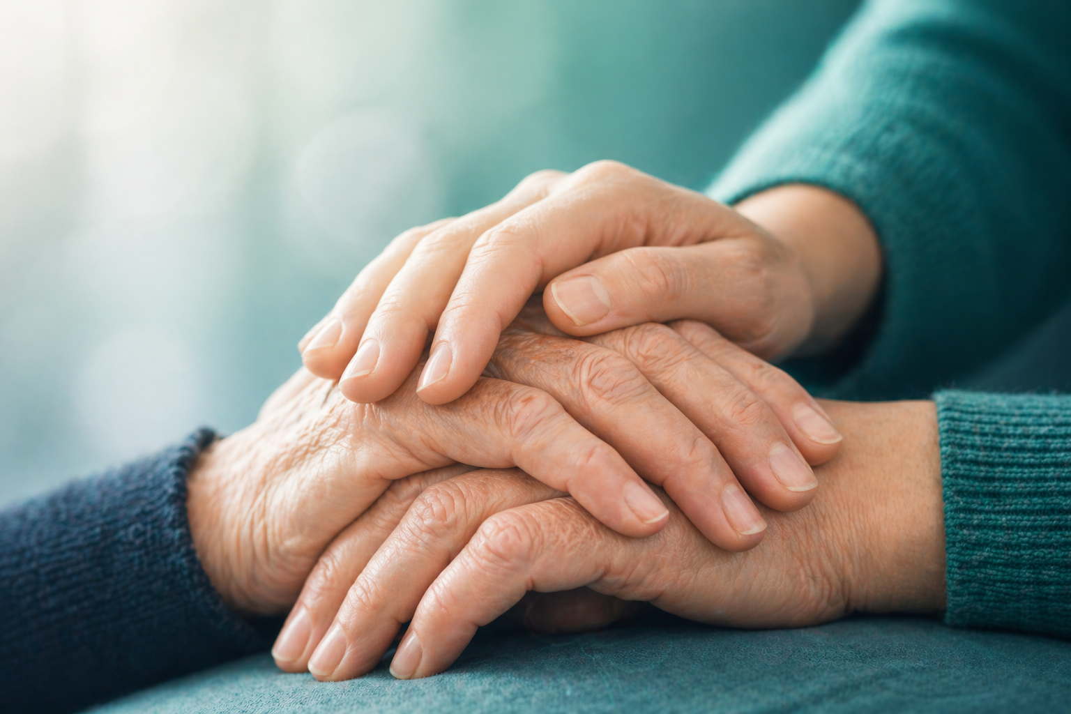 Two pairs of hands holding each other in support